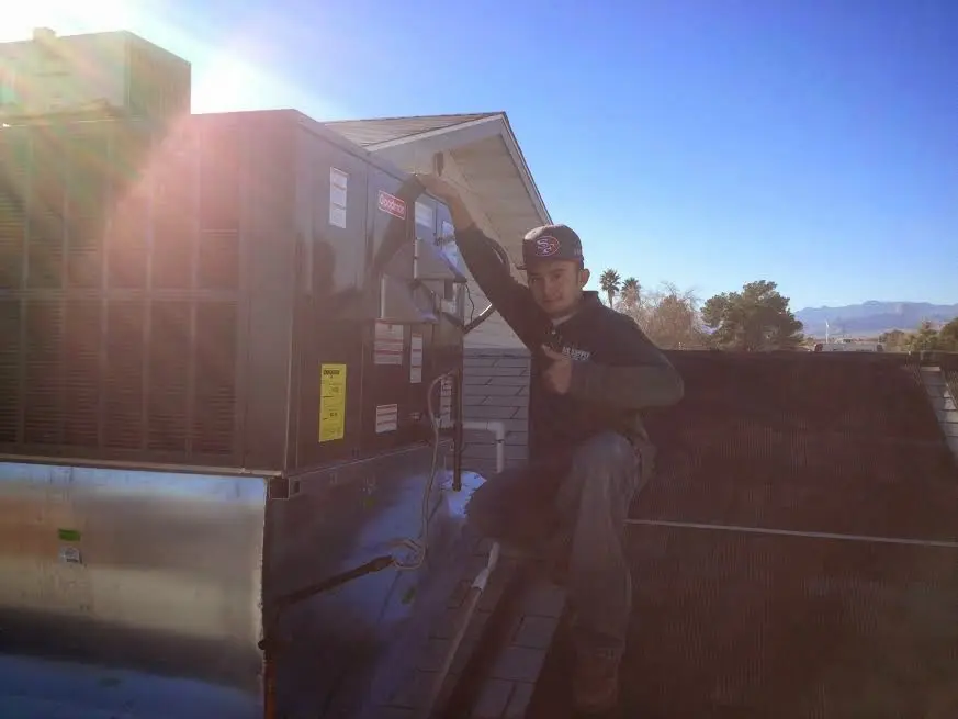 HVAC technician performing HVAC Inspection on a rooftop unit in Hampden
